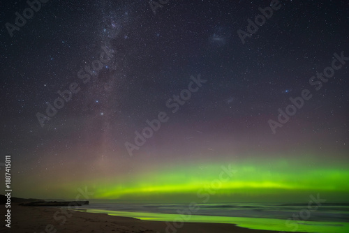 Foto The spectacular green glow of the Aurora Australis with beautiful light reflections on the ocean waves