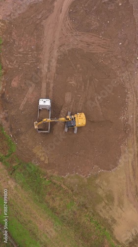 Aerial Earthworks: An overhead shot captures an excavator loading a truck at a construction site, highlighting industry's infrastructure