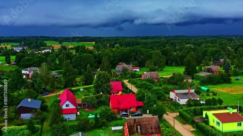 Wallpaper Mural Dark shelf cloud approaches a village with vibrant houses and green fields, aerial view Torontodigital.ca
