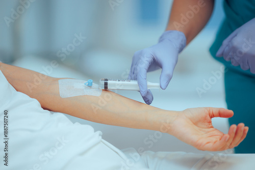Фотография Nurse Uses Syringe to Inject a Concentrated Dose of Medication into an IV