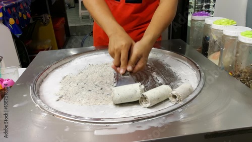 Krabi, Thailand - December 2, 2019 Scraping the stir-fried or rolled ice cream using Oreo and milk, street food vendor.