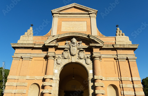 Ancient stone portal Porta Galliera stands majestic under a clear blue sky representing the rich historical heritage of Bologna city