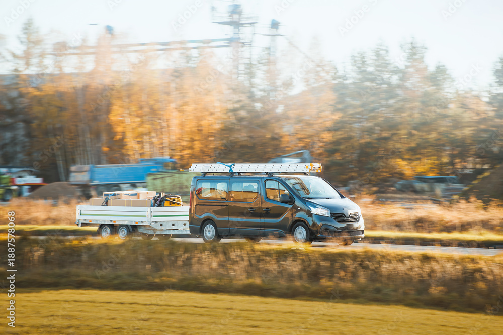 Fototapeta premium Commercial van towing utility trailer on road