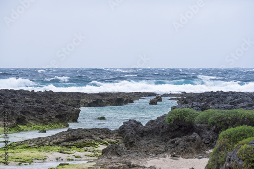 アニメ風の荒れる海と珊瑚礁の海岸、白い波が打ち寄せる冬の海背景素材（コピースペース・デザイン素材）
