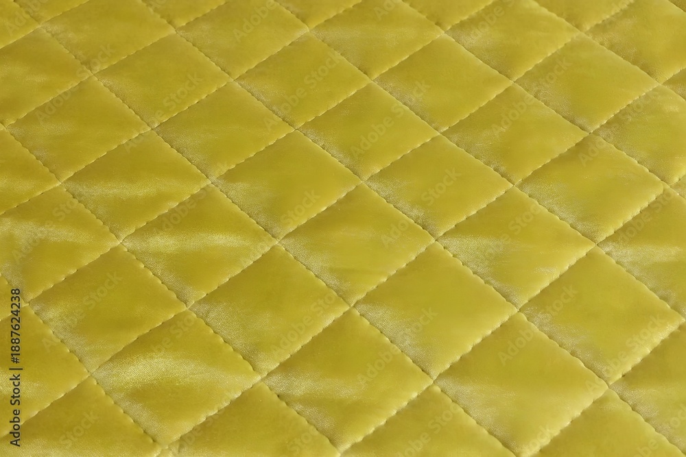 Fototapeta premium yellow-green velvet quilted fabric texture with diamond stitching