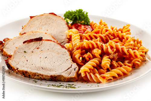 Roast pork loin cutlets with tomato pasta on white background © Jacek Chabraszewski