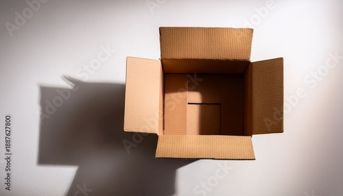 Open Empty Cardboard Box Casting A Shadow On A White Surface Top Down Perspective