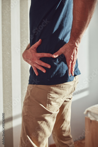Wallpaper Mural Man with hip, back, spine and sciatica pain at home. Torontodigital.ca