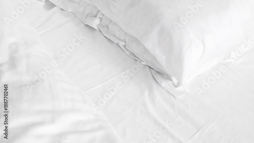 Billede på lærred White bedding with pillows arranged neatly on a soft mattress surface