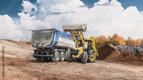 Obraz na plátně Loader works at construction site, moving dirt and filling a trailer with materials