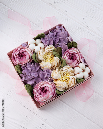 marshmallows in the form of colorful flowers in a box on white boards