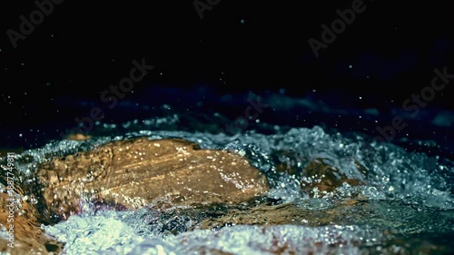 Slow motion ripple waves on dark blue water river.Dramatic night background.Super slow motion detail 4k video.Crystal clear spring river.Advertising concept.Epic mystical black view.Underwater stones