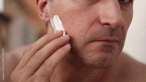 Creamy shaving foam, Closeup of shaving cream application process, White man preparing skin with thick foam in bathroom, Detailed view of shaving foam being spread over lower face in cozy bathroom