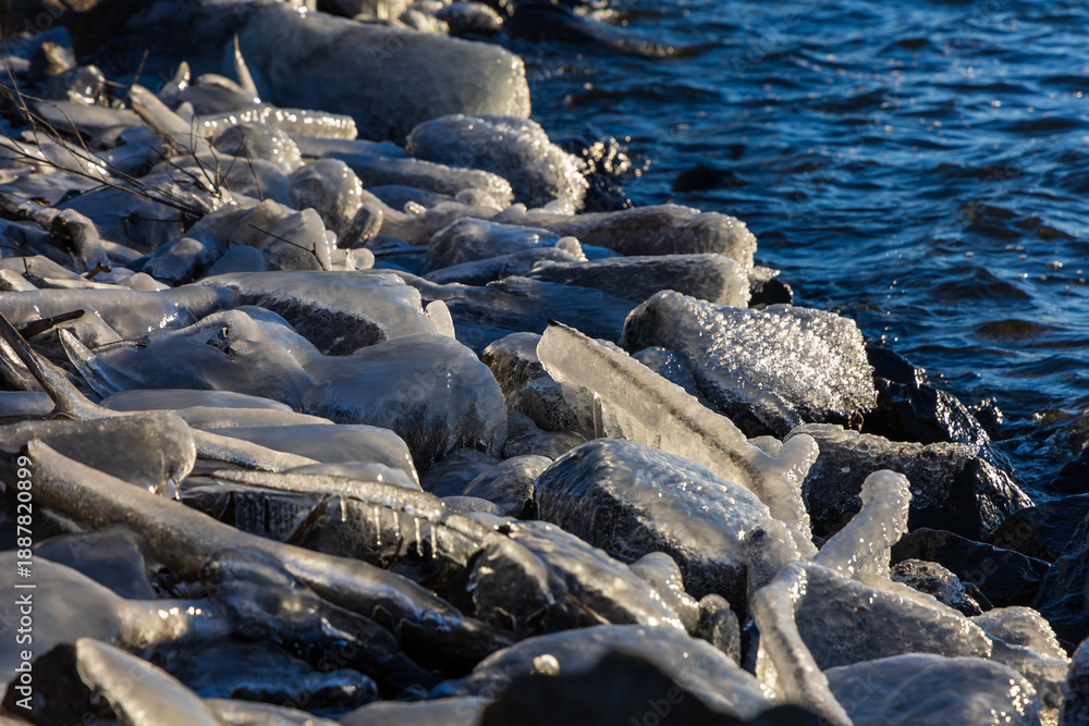 Obraz premium Bizarre ice formations and icicles on the rocky lake shore during freezing winter.