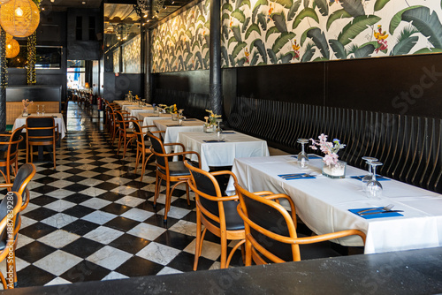 Stylish restaurant interior with checkered floor and wallpaper