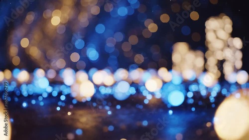 Vibrant blurry bokeh lights in blue and gold tones creating enchanting festive atmosphere with glowing orbs and shining particles everywhere displayed.