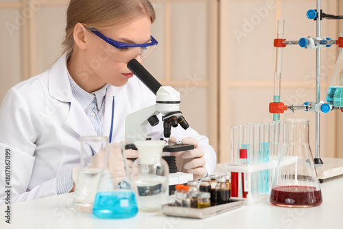Female scientist looking through microscope in laboratory