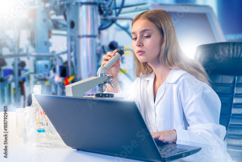 Laboratory research scientist examines samples with microscope while recording results on laptop. Scientific analysis, biomedical research, laboratory diagnostics, experimental studies.