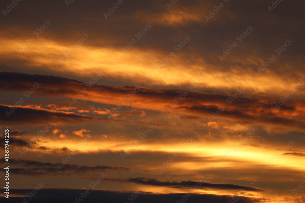 Obraz premium Golden Sunset Sky with Dramatic Layered Clouds
