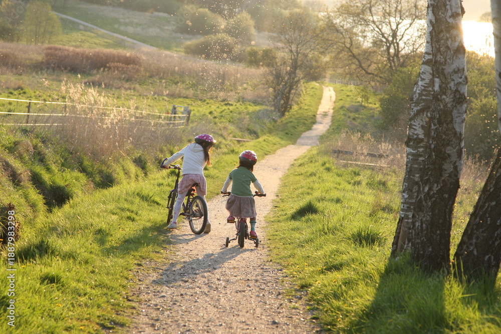 Naklejka premium 2 Children in bikes on a path in nature in Denmark