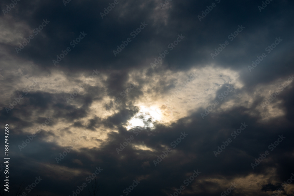 Obraz premium Dramatic dark clouds with sun hiding behind