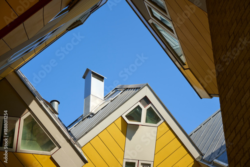 The famous Cube Houses in Rotterdam feature unique architecture with slanted angles and yellow roofs. These modern buildings are a popular tourist attraction in the Netherlands.