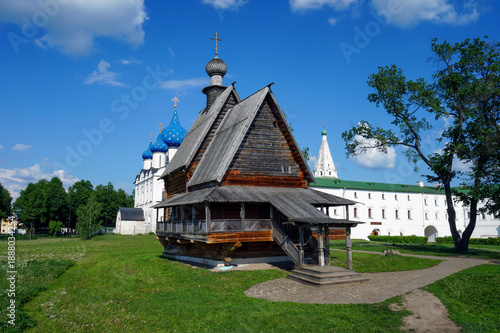 Canvas-taulu Wooden church with blue onion domes in monastery complex