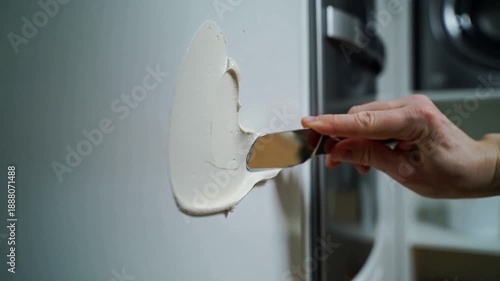 The putty is applied to the wall with a spatula