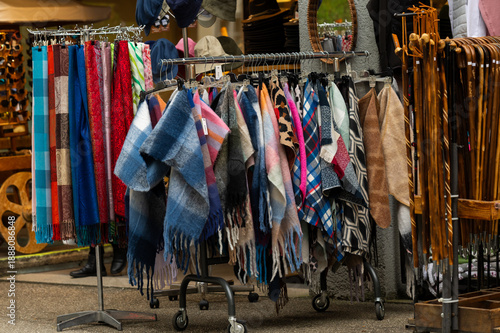 Colorful scarves and shawls displayed for sale at an outdoor street market.