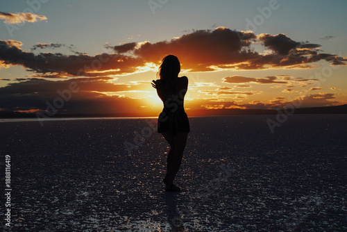 The silhouette of a woman dancing peacefully at sunset.