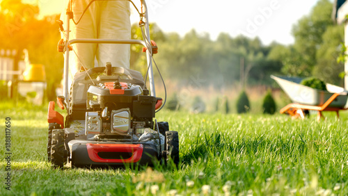 woman with lawn mower in garden plot