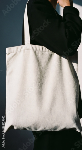 Person carrying stylish large white tote bag in modern setting