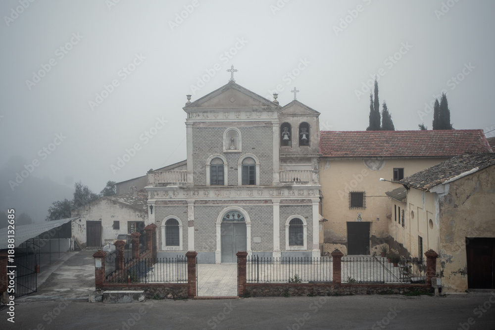 Fototapeta premium Facade of the Hermitage of Light in the El Valle Natural Park, Murcia, Spain, on a foggy day