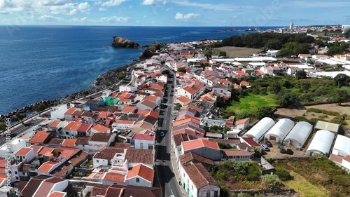 Sweeping aerial photograph of Ponta Delgada coastline on São Miguel Island with volcanic landscape and urban expansion.