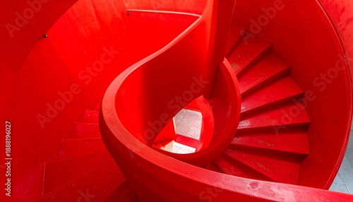 Overhead shot of a vivid, scarlet spiral staircase within an architectural space