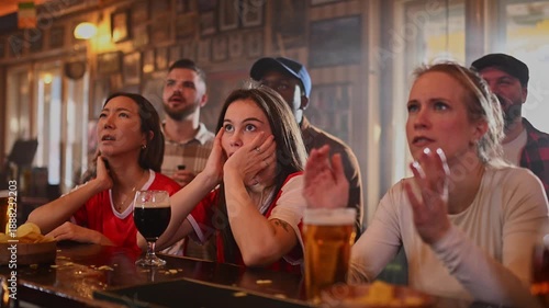 Cheerful football fans celebrating a goal in a sports bar