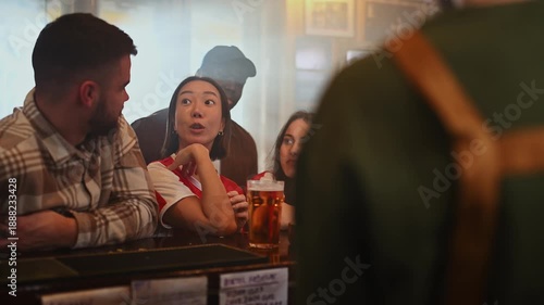 Diverse group of friends chatting and laughing at a bar counter