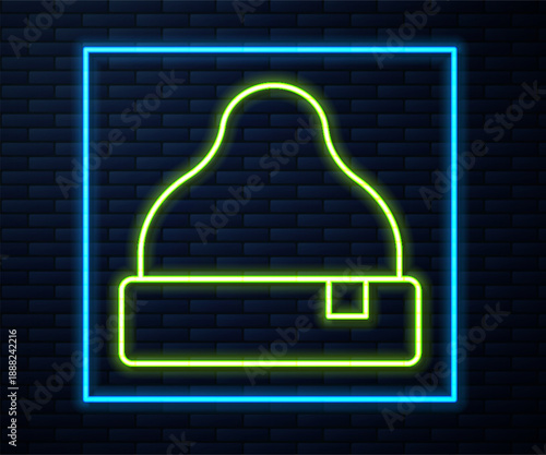 Glowing neon line Beanie hat icon isolated on brick wall background. Vector