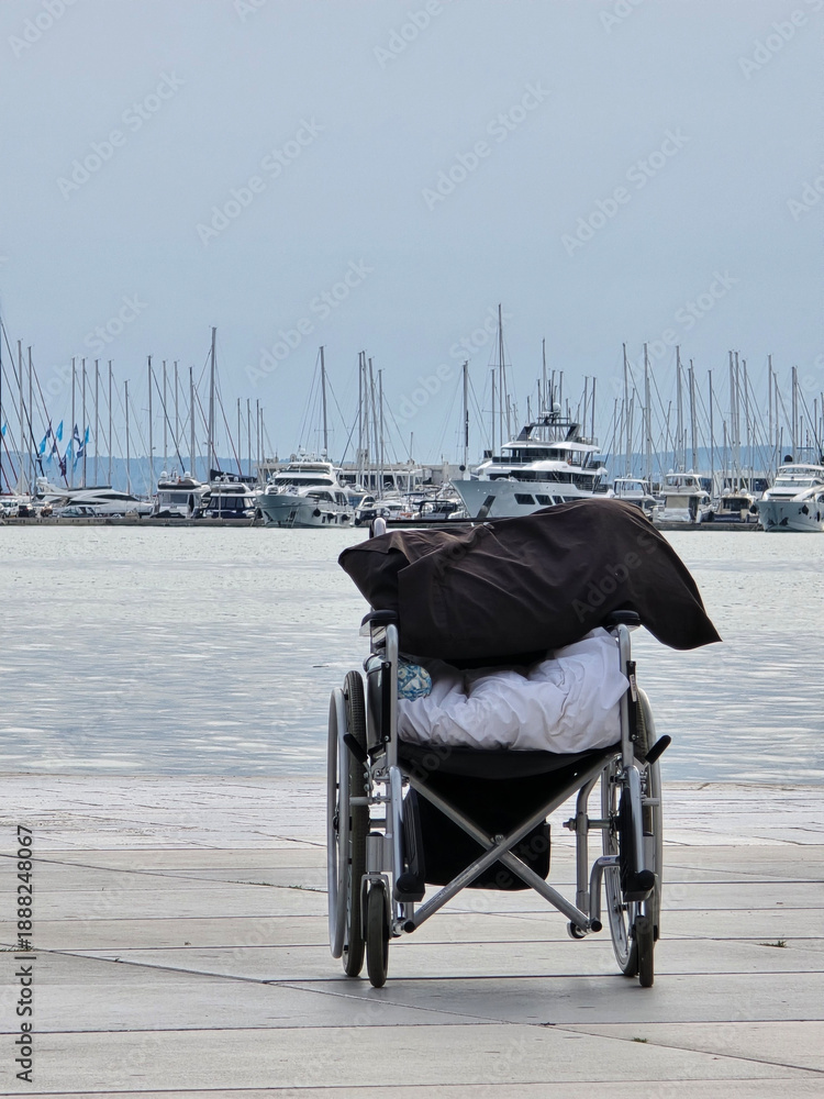 Fototapeta premium Empty Wheelchair at the Harbor with Luxury Yachts and Boats in the Background