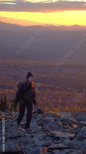 Vertical video of a woman hiking in the Ural Mountains in autumn. Stunning nature scenery with vibrant fall colors. Perfect for travel and nature content
