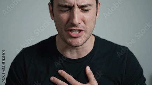 Man experiencing chest pain feeling ill and unwell indoors