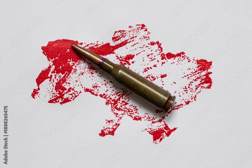 Obraz premium An outline of a map of Ukraine, painted in red paint, and a bullet on a white background, simulated blood