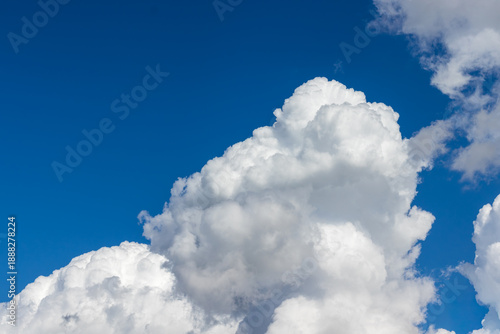 Fotografia Vibrant blue sky with large puffy white clouds