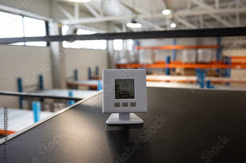 Digital Thermometer on Desk in Modern Warehouse Interior