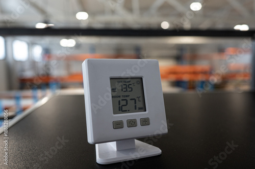 Digital Thermometer on Desk in Modern Warehouse Interior