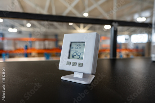 Digital Thermometer on Desk in Modern Warehouse Interior