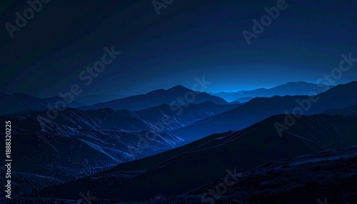 Dark mountain range under a night sky with moonlit peaks.