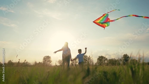 Mother and son flying kite. Group of children are holding kite together. Girl is playing with a kite and a boy is running. A mother and her son are flying a lifestyle kite.