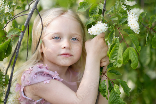 Close-up of a little girl's face in a blooming tree