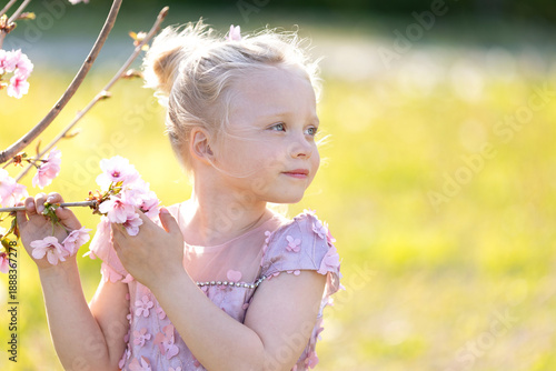 a little girl with a glowing flowering tree background.